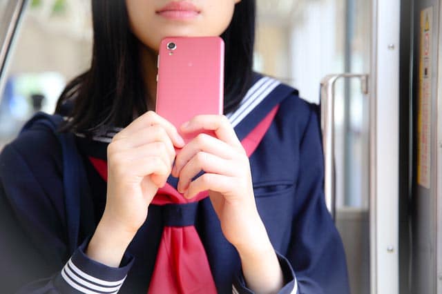 High school student on train with phone