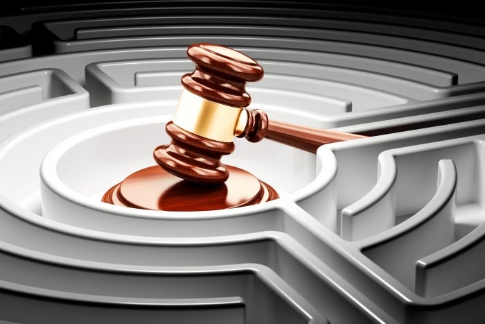 Gavel inside labyrinth maze. 3D rendering