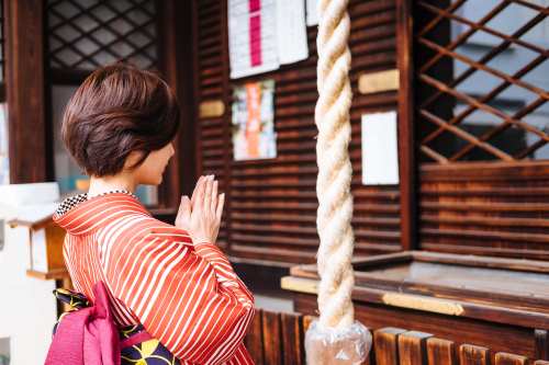 Shinto: Woman praying at a shrine