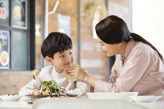 Woman helping young boy