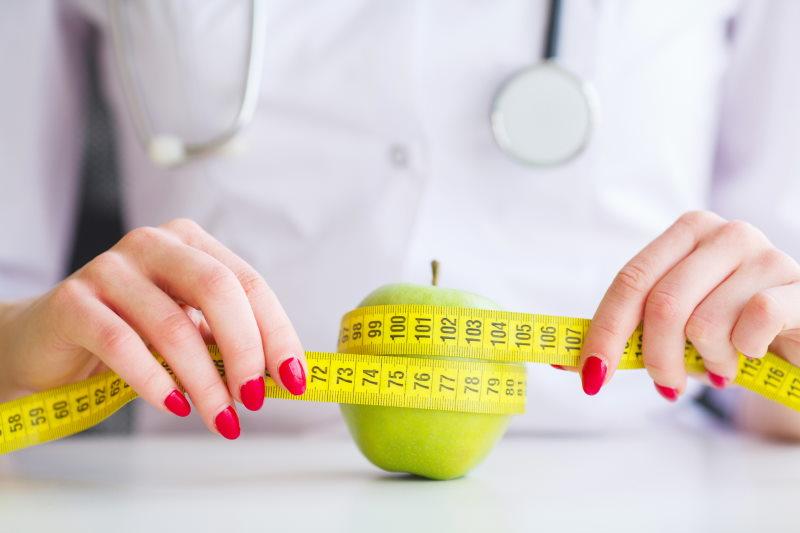 Doctor measuring apple