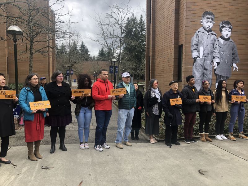 People at Bellevue College holding placards with the names of WWII concentration camps