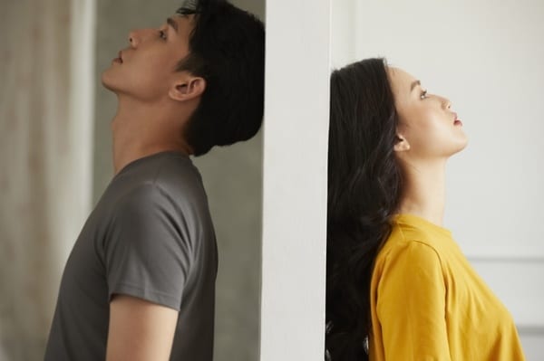 Woman and man on opposite sides of wall