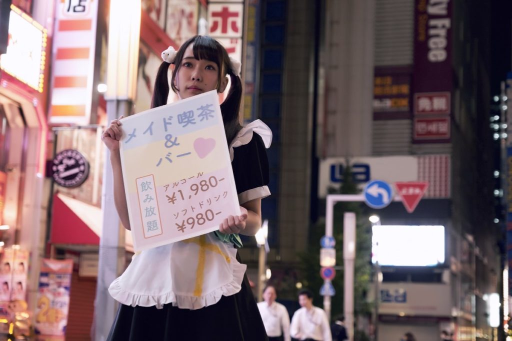 Woman barker advertising for a maid cafe