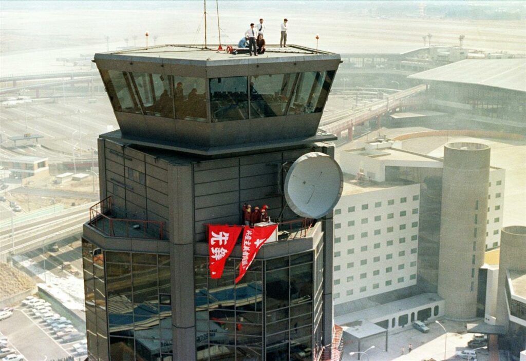 Anti-airport flags hang from the occupied control tower of Narita Airport.