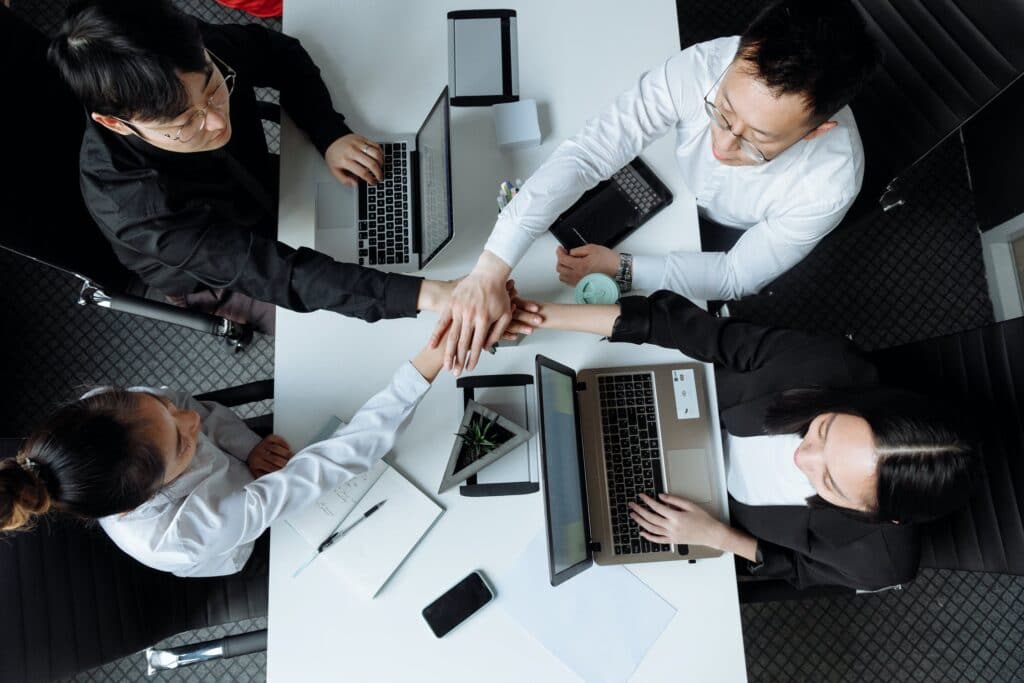 a group of people working together with laptops