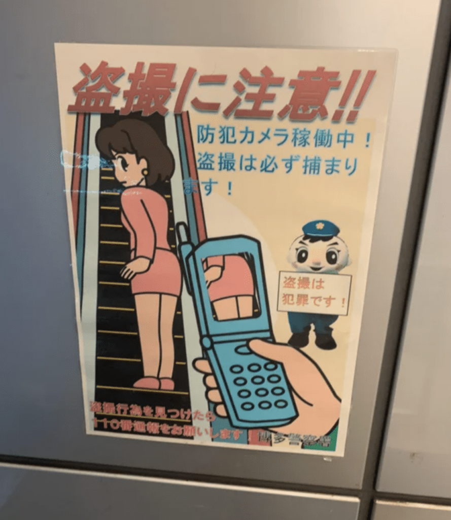 A poster in a train station warns of Tousatsu - nonconsensual upskirt photography.
