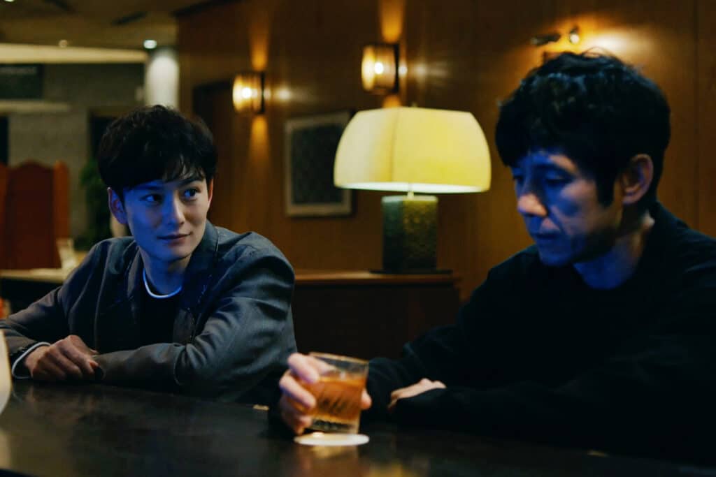 Nishijima Hidetoshi and Okada Masaki share a drink - and a tense conversation, in Drive My Car.