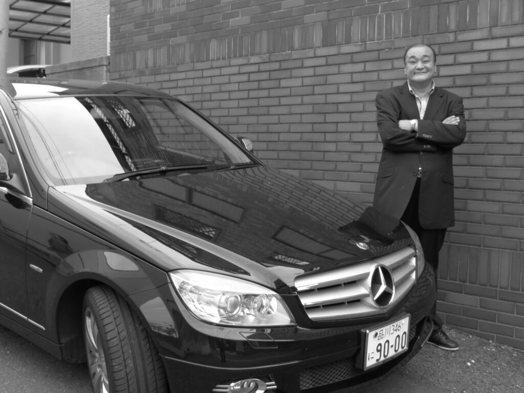 Jake Adelstein's former yakuza bodyguard, Mochizuki-san, alongside the Benz they called the Vice Mobile.