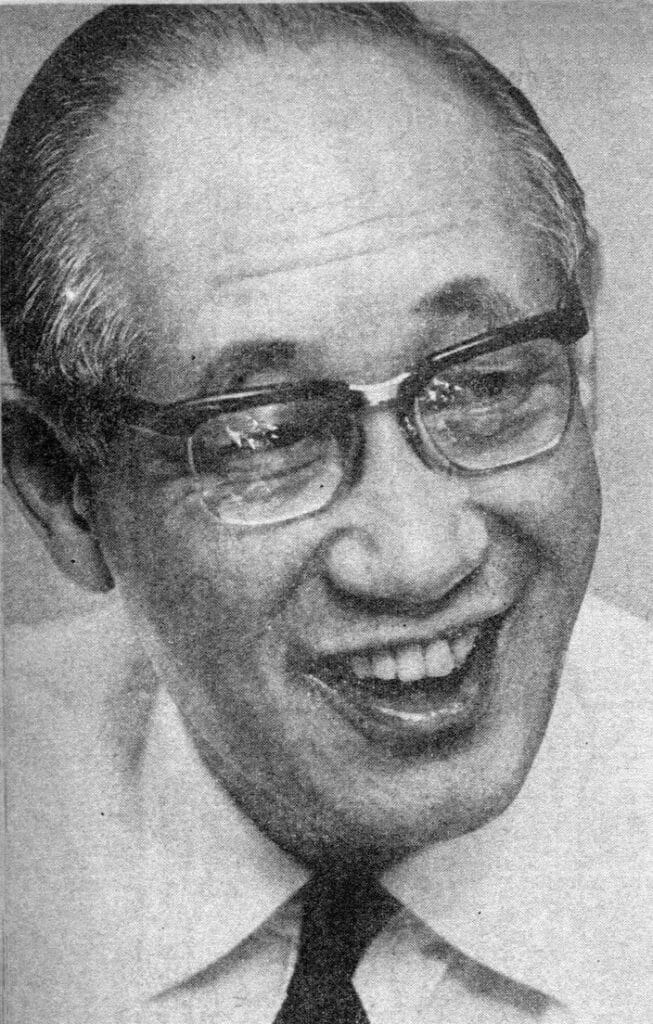 Governor Minobe Ryokichi, wearing rimmed glasses, smiles.
