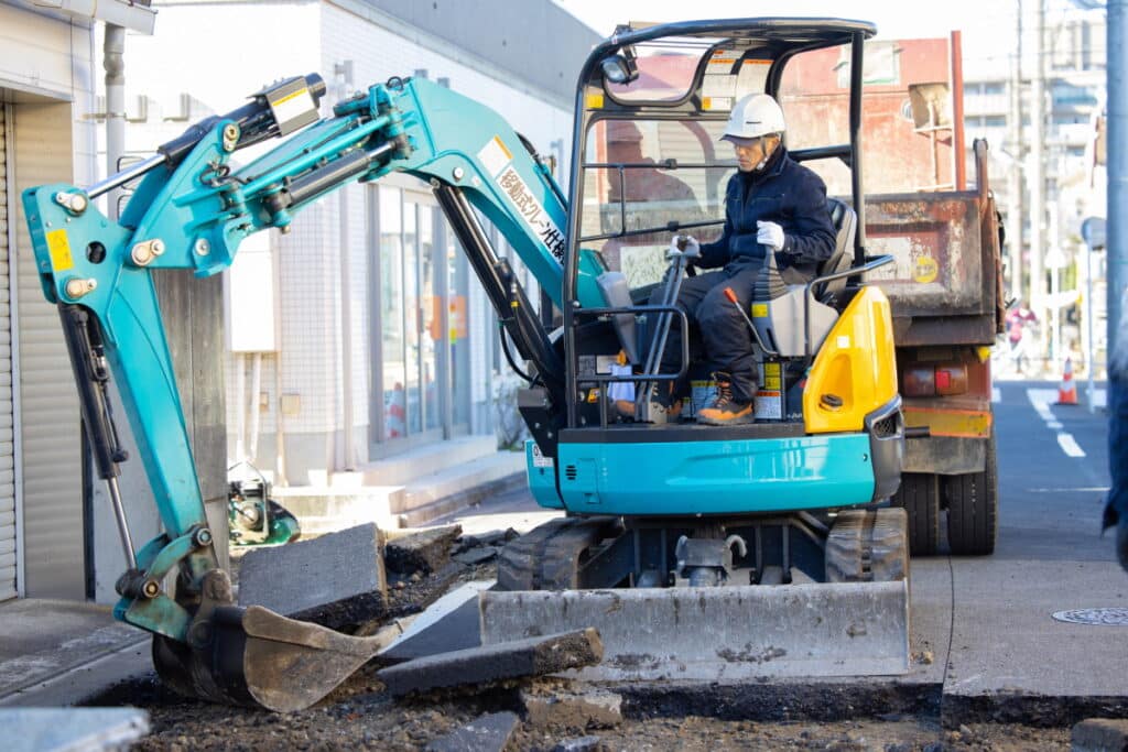 Construction worker operating a scoop