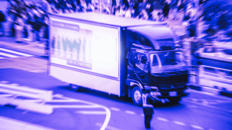 A mobile billboard truck (ad truck) drives through Tokyo.