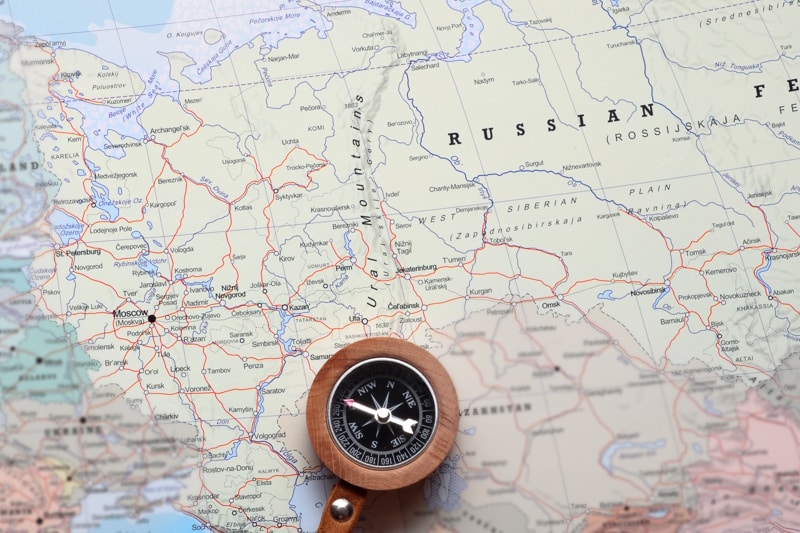 Compass on a map pointing at Moscow Russia, and planning a travel destination