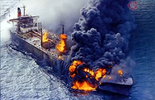 The large tanker Yuyo Maru is on fire, billowing smoke from its prow.