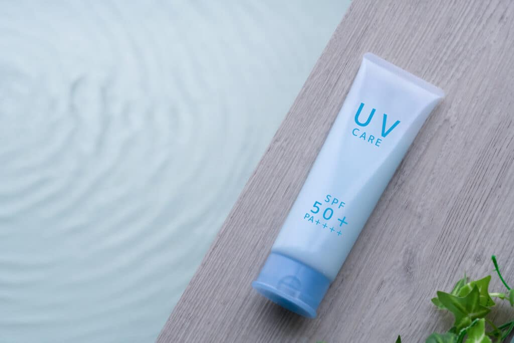 A bottle of sunscreen by the side of a pool