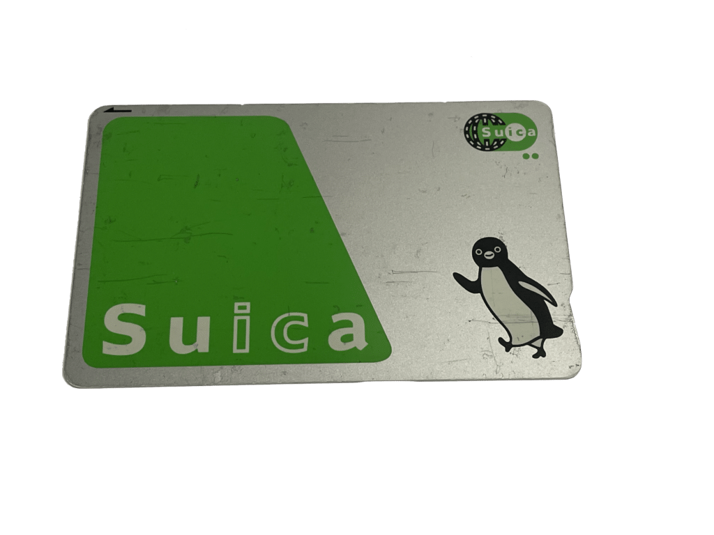 Suica IC card in green and silver with smiling penguin character walking to the left.