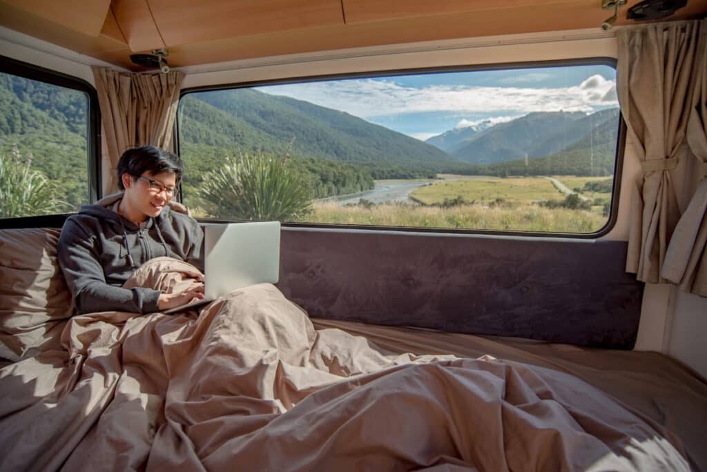 Young man working remotely on laptop - digital nomad