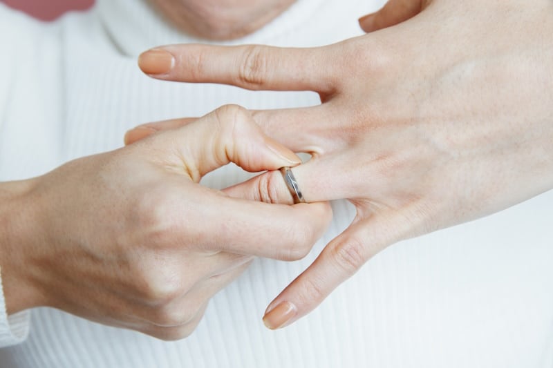 Woman pulling off her wedding ring 