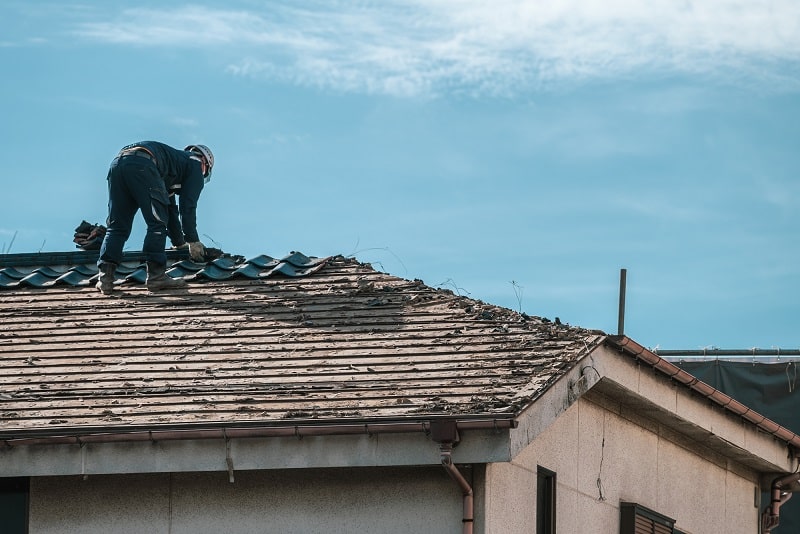 Man working on dilapidated roof