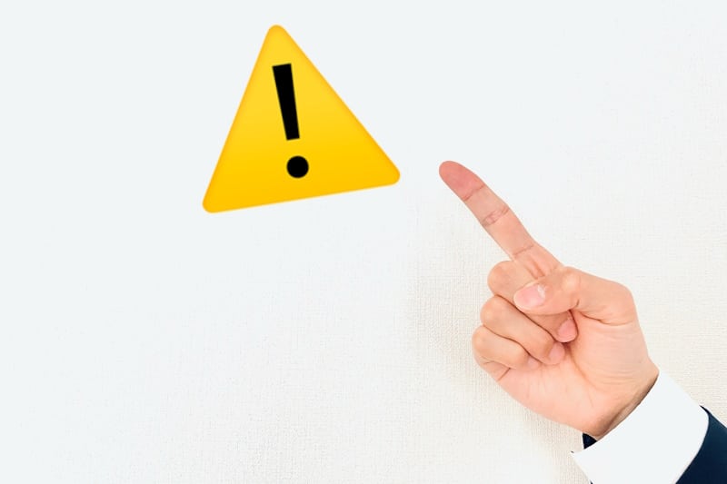 Hand pointing to a warning sign