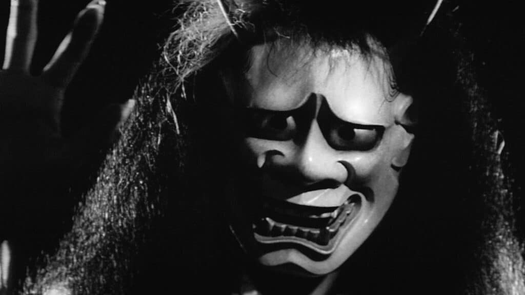 A close up of a ghostly figure in a noh mask in the film Onibaba.