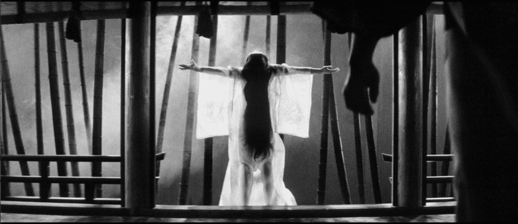 A woman in see-through kimono stands with arms outstretched in the film Kuroneko.