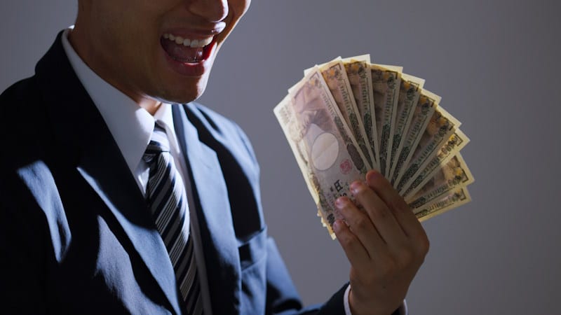 Businessman holding a lot of yen