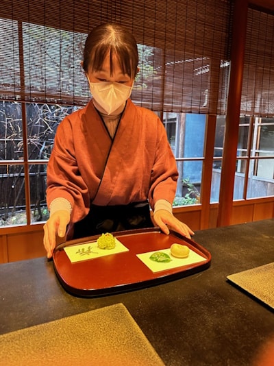 A teahouse in Higashi Chaya - woman serving sweets on a tray
