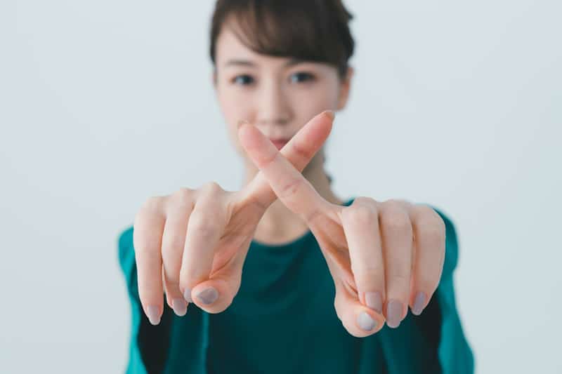 Woman crossing her fingers at the screen