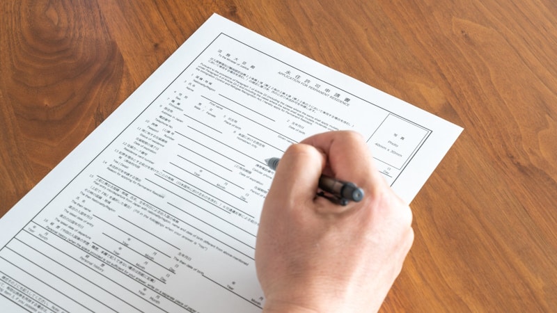 Someone filling out an application for permanent residence