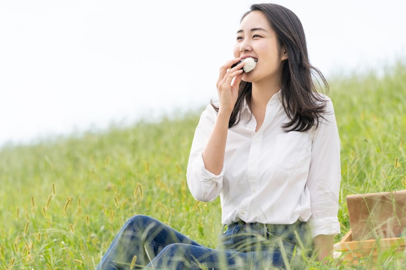 Woman eating onigiri with one hand