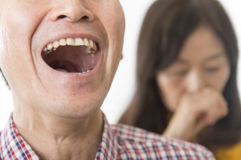 Man offending woman with his bad breath