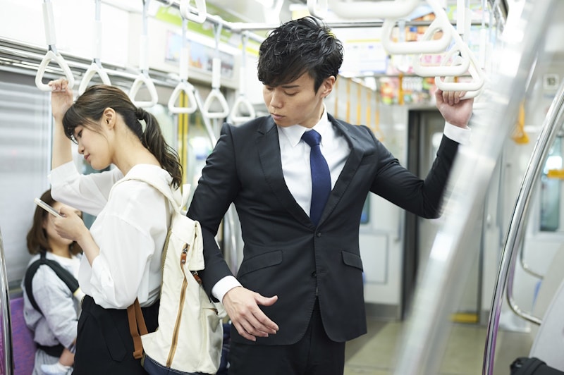 Man bumping into a woman's backpack on a train
