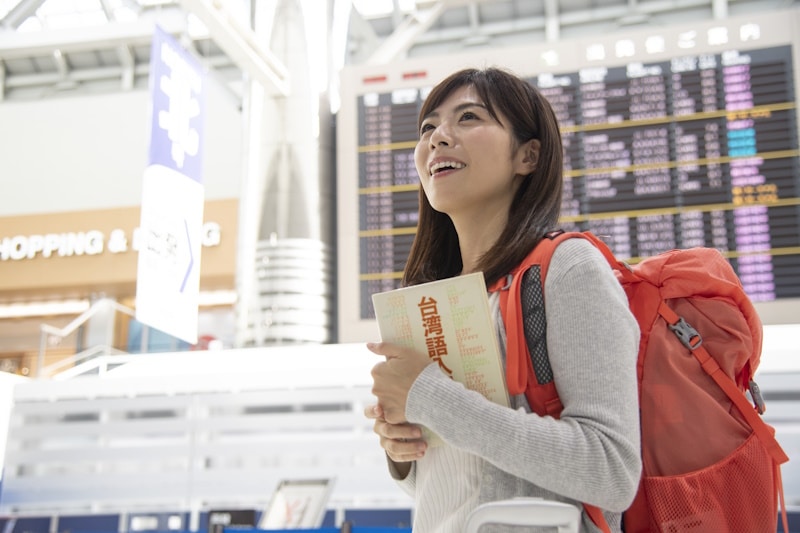 Woman at airport holding a book on Traditional Chinese