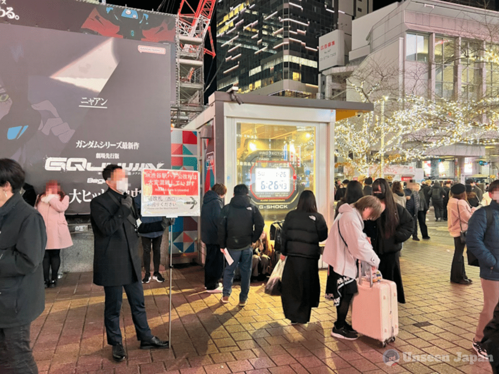 Man standing outside Hachiko Gate at Shibuya Station redirecting traffic
