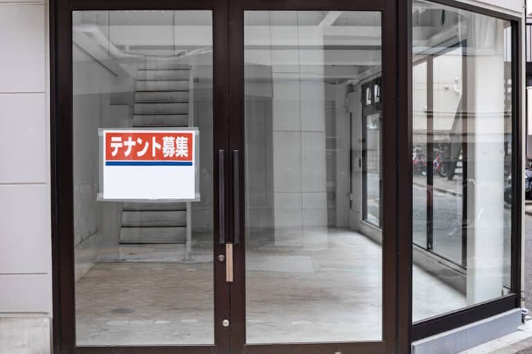 Empty storefront with sign in Japanese saying "Tenant Wanted")