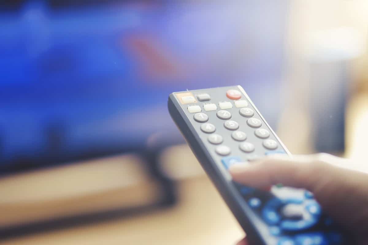 Person turning channel on TV with remote control