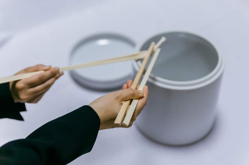 A (sanitized) picture of hashi-watashi, passing bone fragments between chopsticks into a funerary urn