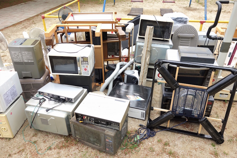 Various electronics and TV stands, etc. in a large pile on the ground