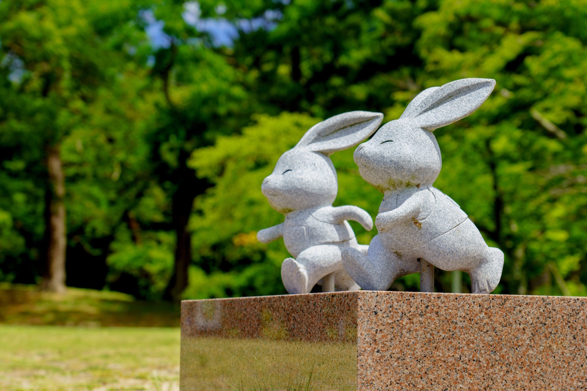Picture of two stone rabbits running on their hind legs like humans