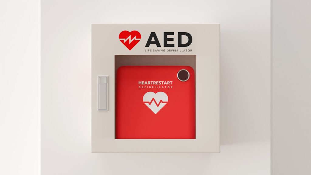 AED device mounted on a wall behind a glass case