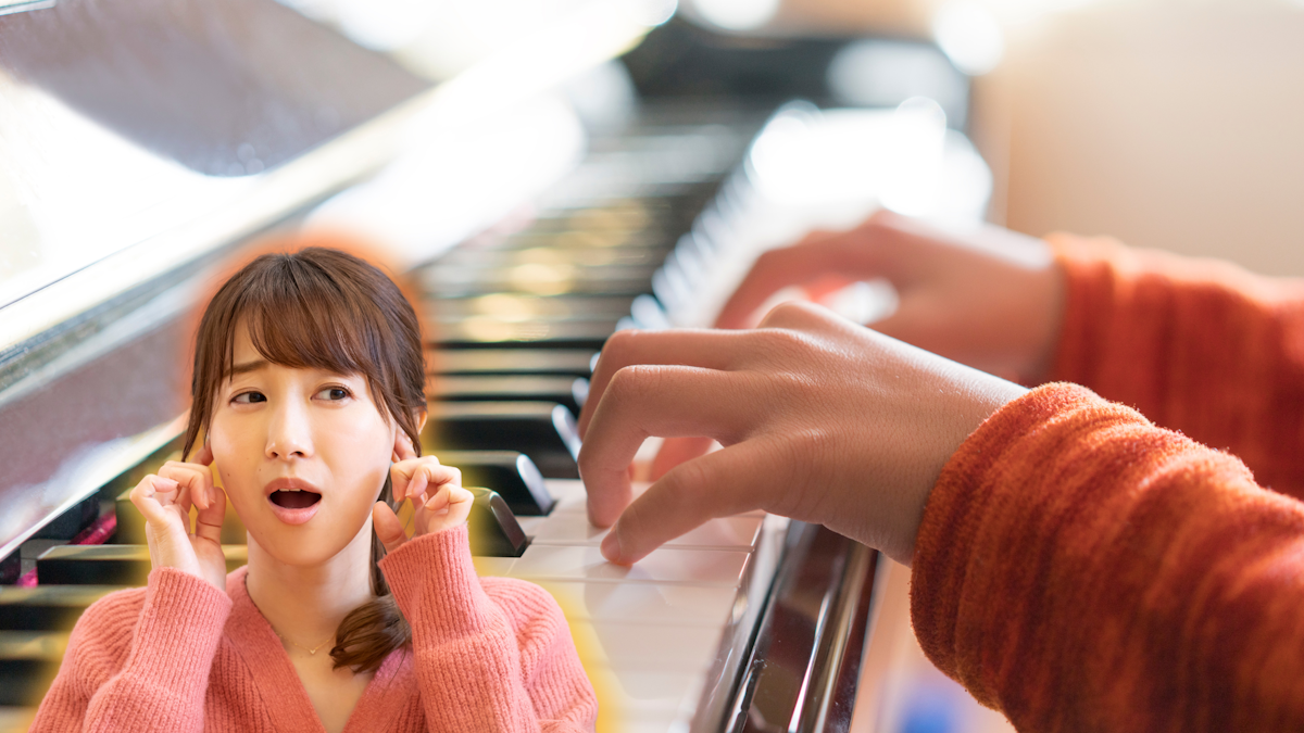 Kid plays on a piano while a woman plugs her ears in horror