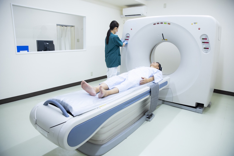 Female medicla professional preparing a man for a CT scan