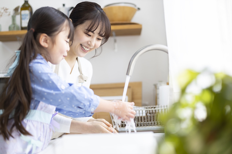 Woman and her daughter washing dishes