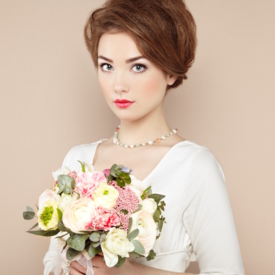 Pretty woman dressed in white holding  flowers