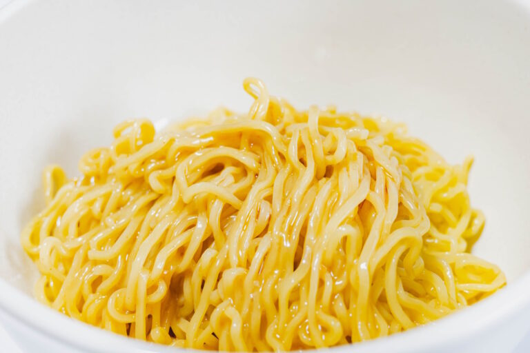 Glistening pile of ramen noodles in a white bowl