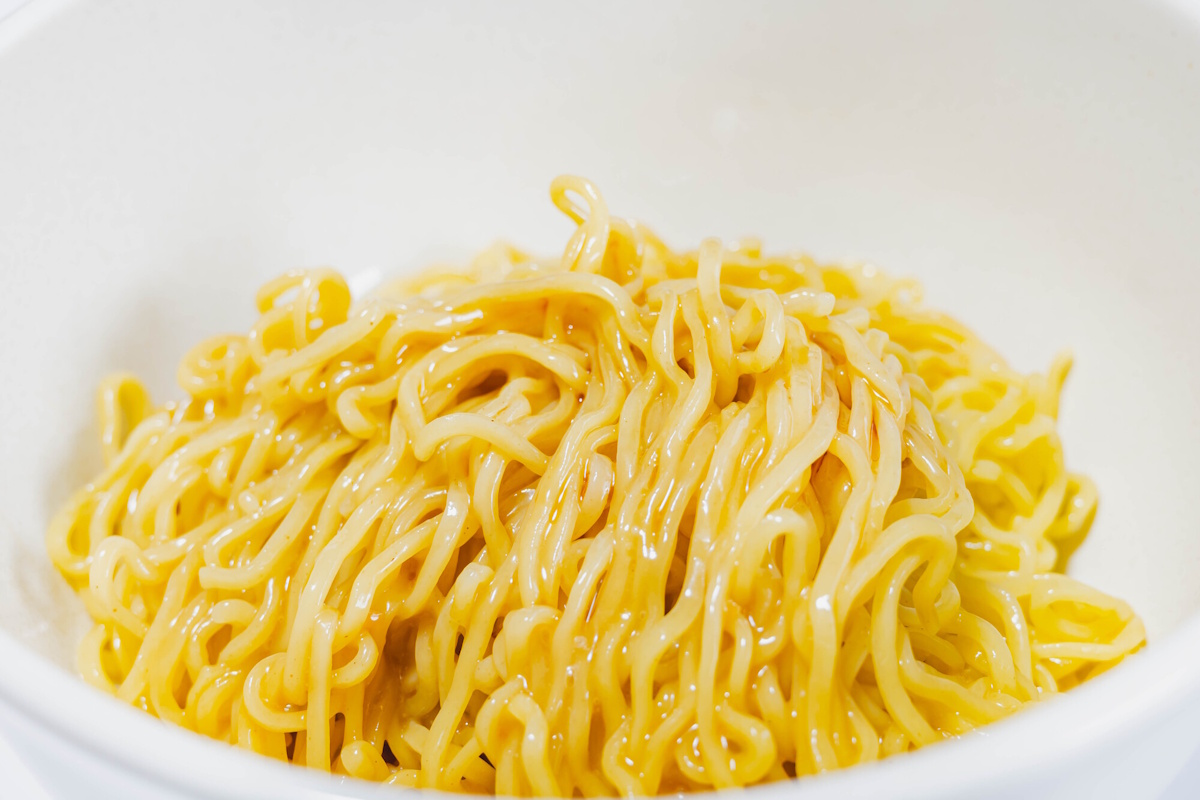 Glistening pile of ramen noodles in a white bowl