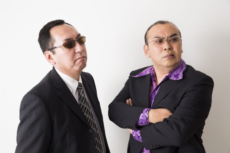 Yakuza style guys, both in suits and glasses and one with a purple shirt