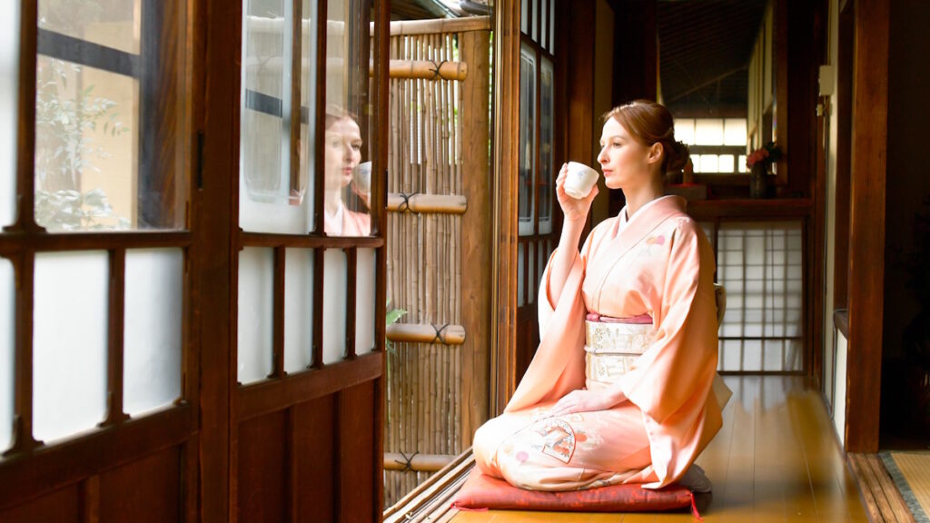 Woman drinking tea inside of an old traditional Japanese house/ryokan