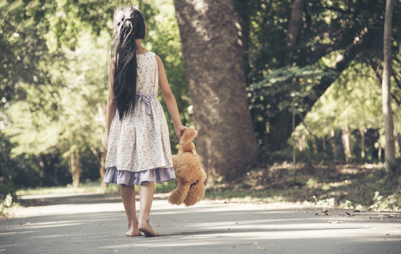 Picture of girl holding a teddy bear by one arm